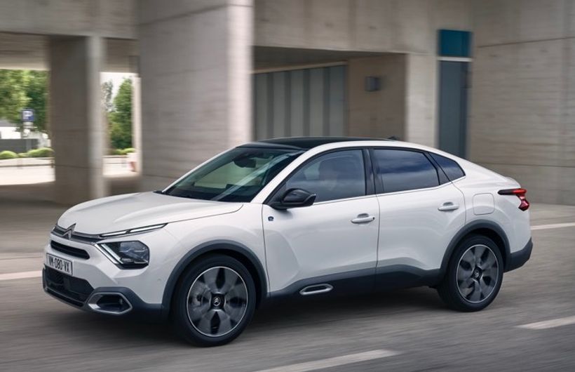White Citroen e-C4X side profile view while driving